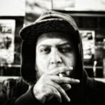 grayscale photography of man holding cigarette