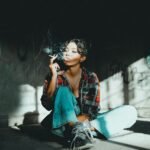 woman in red and blue plaid button up shirt and blue denim jeans sitting on floor