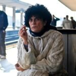 man sitting and smoking at the train station